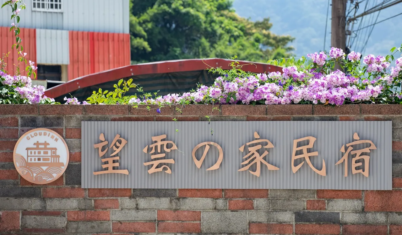 磚牆上的望雲の家民宿木招牌